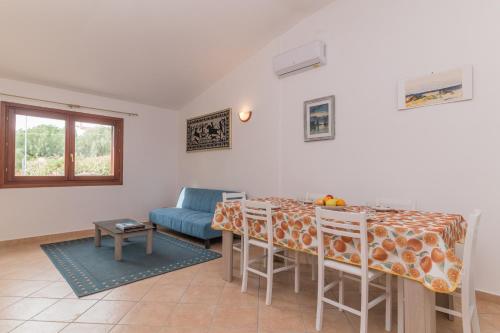 sala de estar con mesa y sofá en La Dimora Di Montelittu With AC - Happy Rentals, en Loiri