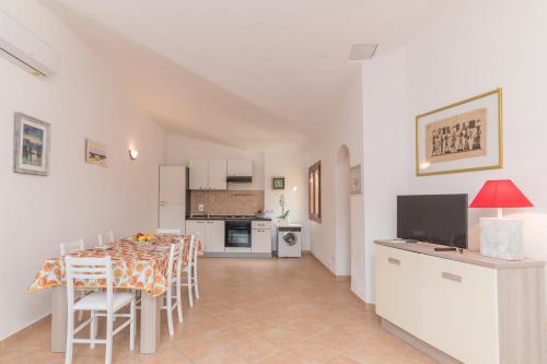 cocina y comedor con mesa y TV en La Dimora Di Montelittu With AC - Happy Rentals, en Loiri