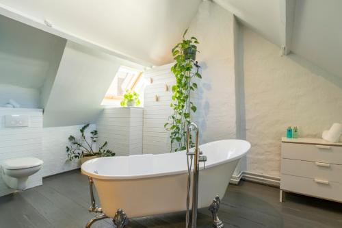a bathroom with a white tub with plants on the wall at The Saffron Dress in Antwerp