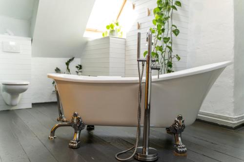 a bath tub with a potted plant in a bathroom at SHWAY - The Saffron Dress in Antwerp