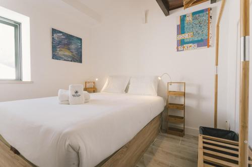 um quarto com uma grande cama branca com toalhas em Best Houses 65 - Sea & Surf House Consolação na Consolação