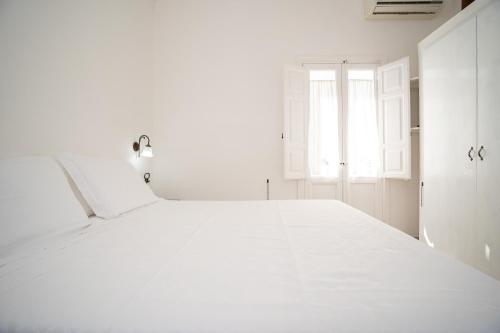 a white room with a bed and a window at Tenuta del Barco WineRestaurant and Hospitality in Pulsano