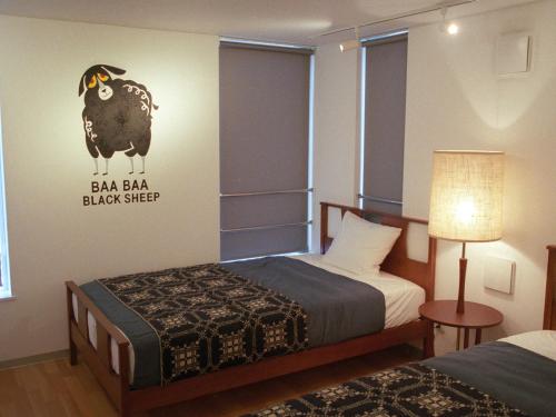 a bedroom with a bed and a black sheep on the wall at The Aoca Tokyo Sanno in Tokyo