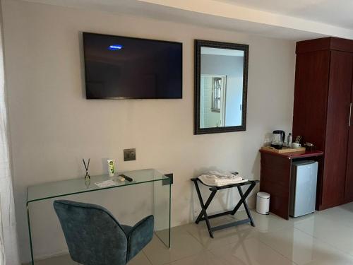 Zimmer mit einem Glastisch und einem TV an der Wand in der Unterkunft Mo'Acress Lifestyle 