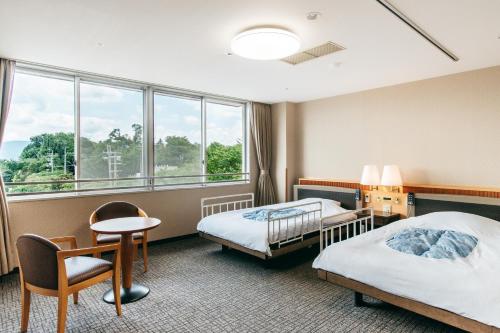 Habitación de hotel con 2 camas y ventana en KAMENOI HOTEL Tondabayashi, en Tondabayashi