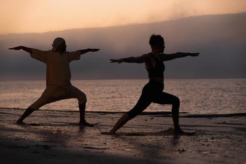 two men are doing yoga on the beach at Oasis212 Dakhla in Dakhla