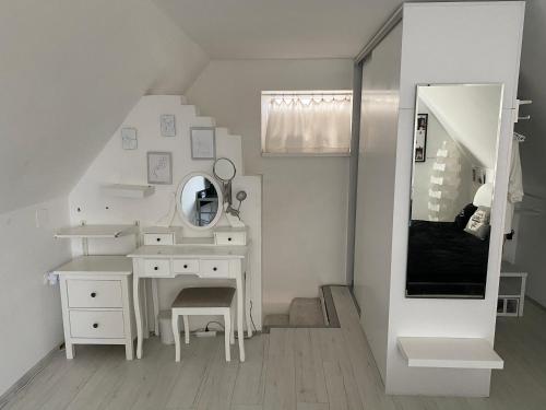 a white bathroom with a vanity and a mirror at Otello vendegház in Szekszárd