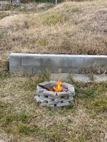 a fire pit in the grass in a field at Otello vendegház in Szekszárd