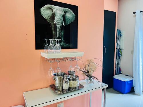 a wall with a picture of an elephant and glasses at Eagle Beach Aruba Breeze Condominium Melon in Palm-Eagle Beach