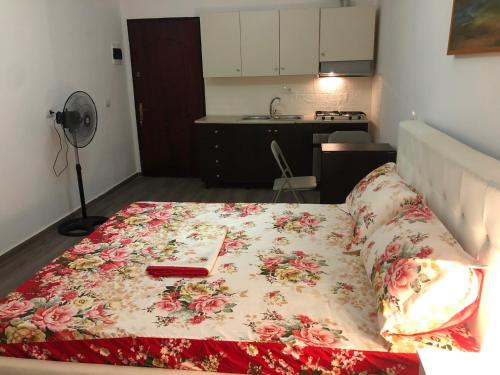 a bed with a floral blanket on it in a room at White Apartment in Golem