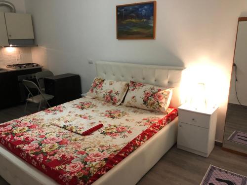 a bedroom with a bed with a floral bedspread at White Apartment in Golem