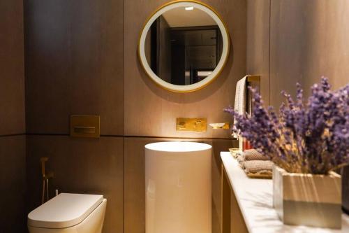 a bathroom with a toilet and a mirror at Private Pool Apt. Five Palm Jumeirah up to 6guest in Dubai