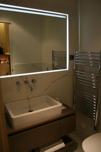 une salle de bain avec un lavabo et un grand miroir dans l'établissement Cirque Deluxe Studio Apartment, à Paris