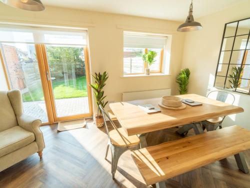 a dining room with a wooden table and a chair at Pass the Keys New 3bedroom house with free parking on premises in Nottingham