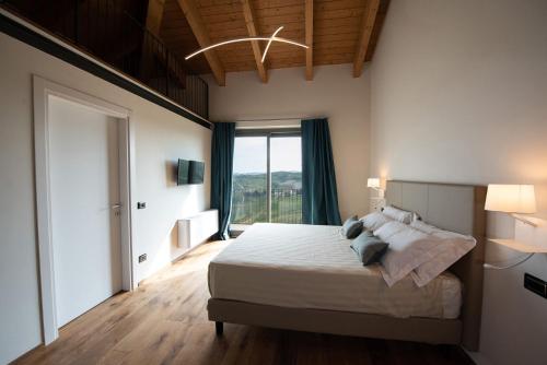 1 dormitorio con cama y ventana grande en Bric D'Alù - Barbaresco, en Barbaresco