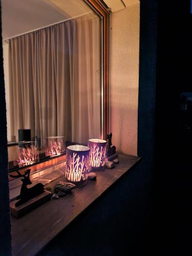 a table with two lamps on it in front of a window at Casa Capricorn Nähe Laax in Sagogn
