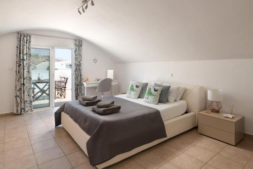 Un dormitorio blanco con una cama y un sofá. en Villa Paradeiso with Private Pool, en Lindos