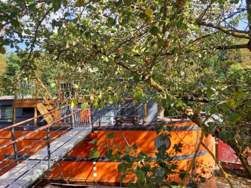an orange boat is sitting under a tree at Appartement atypique indépendant sur péniche in Metz