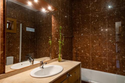 a bathroom with a sink and a mirror and a tub at Matos Casas de Campo in Cabeceiras de Basto