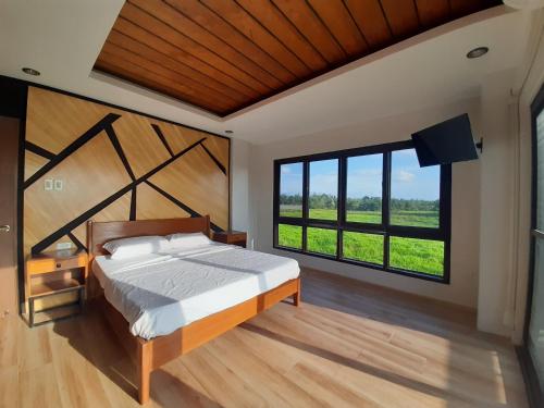 a bedroom with a large bed and a large window at Winch House in Pili