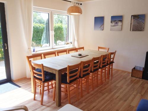 ein Esszimmer mit einem Holztisch und Stühlen in der Unterkunft Annemaries Nordseehaus in Butjadingen
