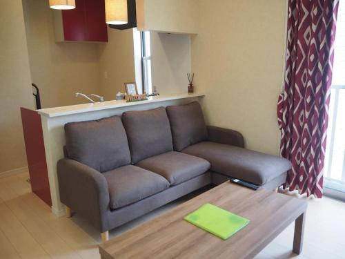 a living room with a couch and a coffee table at Harbour Inn & Suites 202 in Niigata