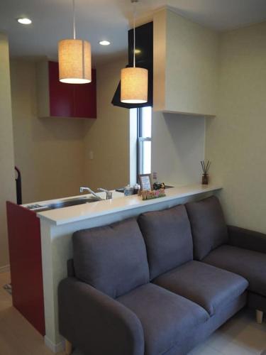 a living room with a couch next to a kitchen at Harbour Inn & Suites 202 in Niigata