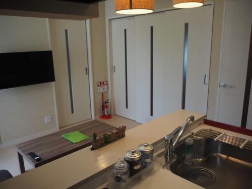 una encimera con fregadero y una cocina con armarios blancos. en Harbour Inn & Suites 202 en Niigata
