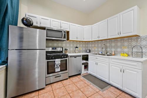 a kitchen with white cabinets and a stainless steel refrigerator at Lincoln Park Gem in Chicago