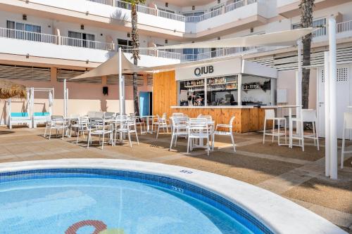un patio al aire libre con piscina y un restaurante en Apartamentos Vibra Panoramic, en Ibiza