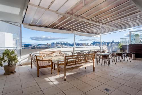 a patio with tables and chairs and a view of the city at Victory Suites in Juiz de Fora