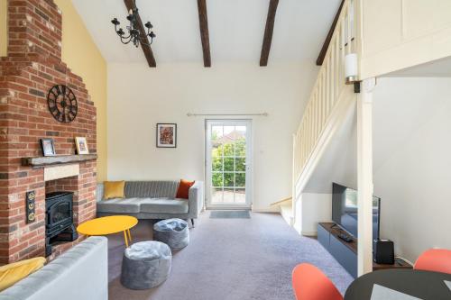 a living room with a couch and a fireplace at 20 Hazelnut Grove Spacious Contemporary 2-Bed House in York - Pass the Keys in York