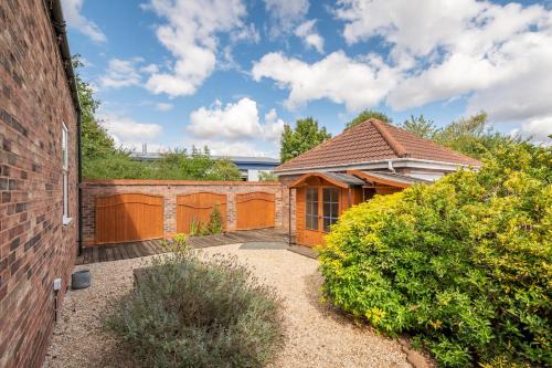 a house with a gate and a brick building at 20 Hazelnut Grove Spacious Contemporary 2-Bed House in York - Pass the Keys in York