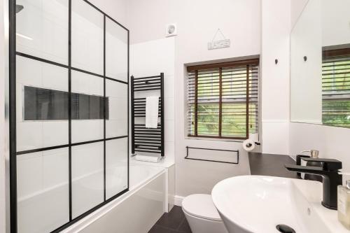 a white bathroom with a sink and a toilet at 20 Hazelnut Grove Spacious Contemporary 2-Bed House in York - Pass the Keys in York