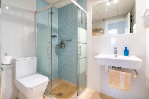 a bathroom with a toilet and a sink and a shower at Apartamentos Delamar in Carboneras