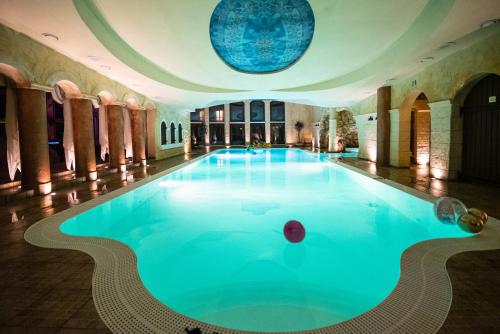 a large swimming pool in a building with a ceiling at Hotel Azzun Orient SPA&Wellness in Kromerowo