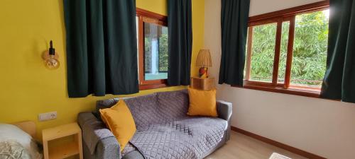 a living room with a couch and two windows at Kasa d'Vizin in Paul