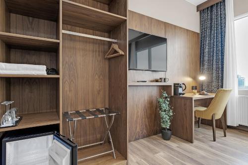 Zimmer mit Holzwänden, einem Schreibtisch und einem TV in der Unterkunft Alva Hotel in Reykjavík