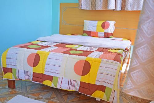 una cama con una colcha colorida en una habitación en TAITA LUXURY HOTELS LTD en Wundanyi