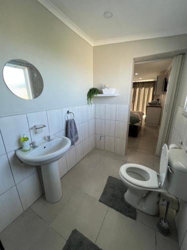 a bathroom with a toilet and a sink at Gussella Lodge in East London
