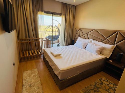 ein Schlafzimmer mit einem großen Bett mit weißer Bettwäsche und Kissen in der Unterkunft Agate 212 Lovely 2-bedrooms apartment with pool & golf view in Marrakesch