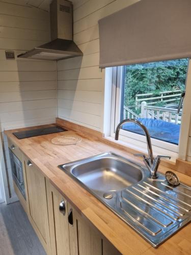 a kitchen counter with a sink and a window at Glamping Hut - Sleeps 2 hot tub & parking in Welshpool