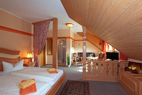 ein Schlafzimmer mit einem Bett und ein Wohnzimmer in der Unterkunft Hotel Berglandstübel in Hammerbrücke