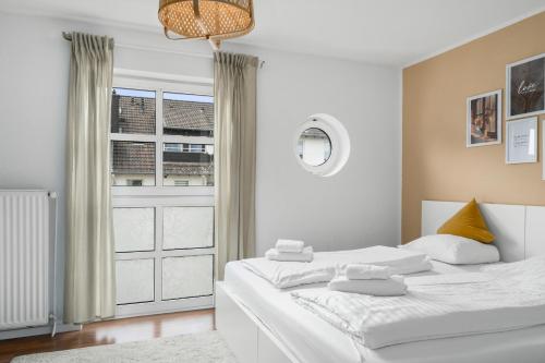 um quarto branco com 2 camas e uma janela em Entspanntes Wohnen in Düren em Düren - Eifel