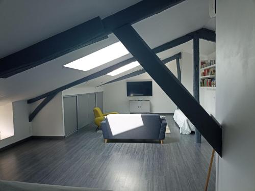 um quarto loft com um sofá e uma televisão em Le Coustalou em Livinhac-le-Haut