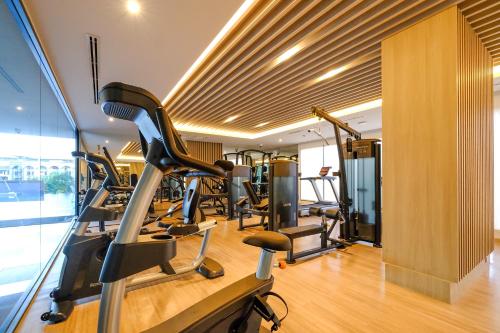a gym with treadmills and a row of exercise bikes at Thaya Hotel Bangkok in Bangkok
