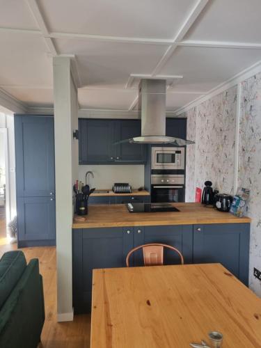 uma cozinha com armários azuis e uma mesa de madeira em Stunning 1 Bedroom Lodge em Welshpool