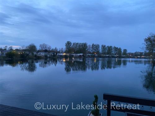 uma vista para um grande lago à noite em Lakeside Retreat With Hot Tub & Fishing Peg at Tattershall Lakes Country Park em Tattershall
