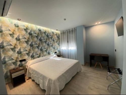 a bedroom with a bed and a wall at Aureo Alojamiento Urbano in Abarán