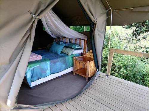 a bed inside of a tent with a canopy at Chosen Glamping Tents in Graskop
